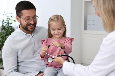 Photo of Father and her little daughter having appointment with doctor in hospital