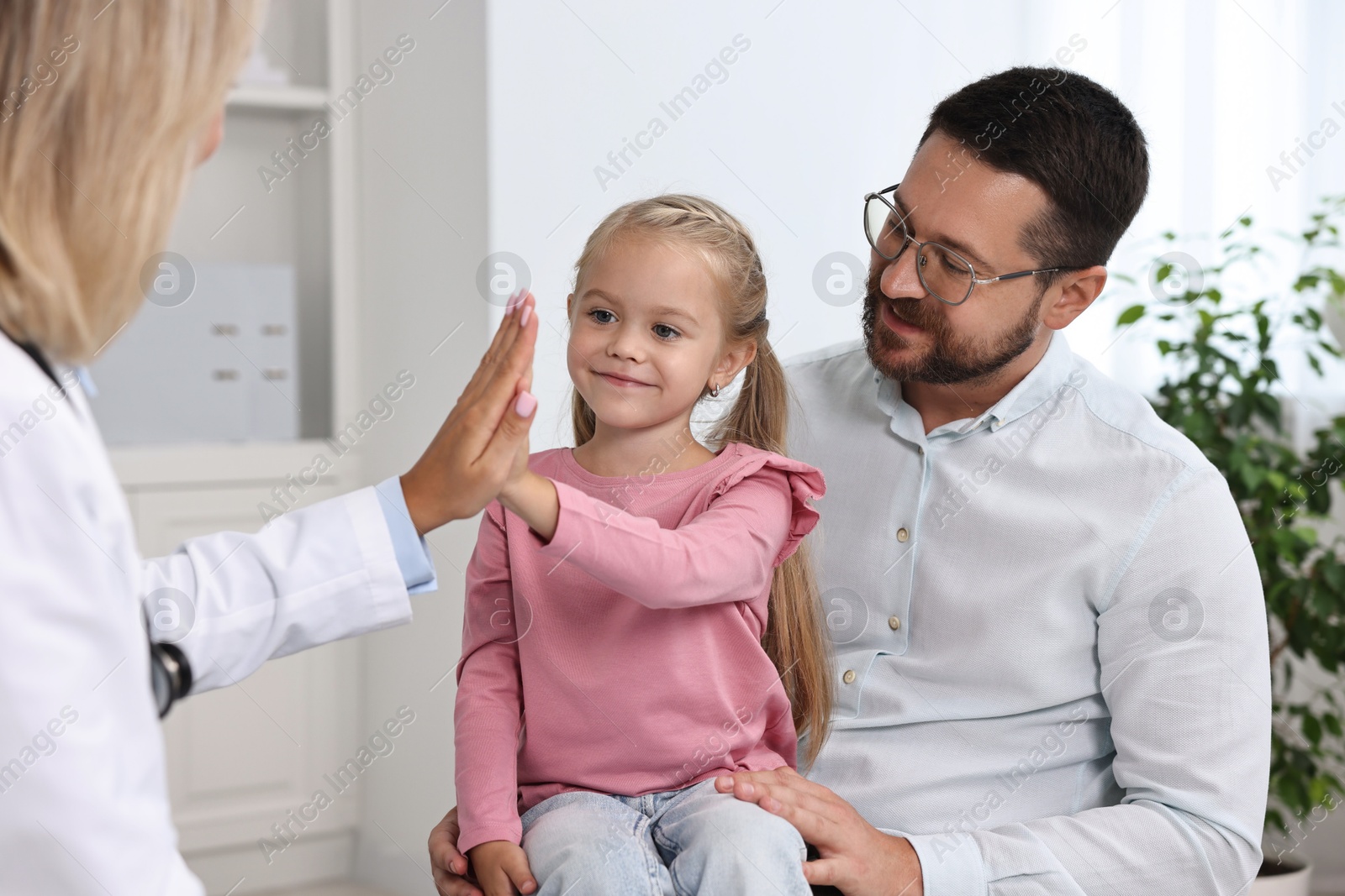 Photo of Little girl and her father having appointment with doctor in hospital