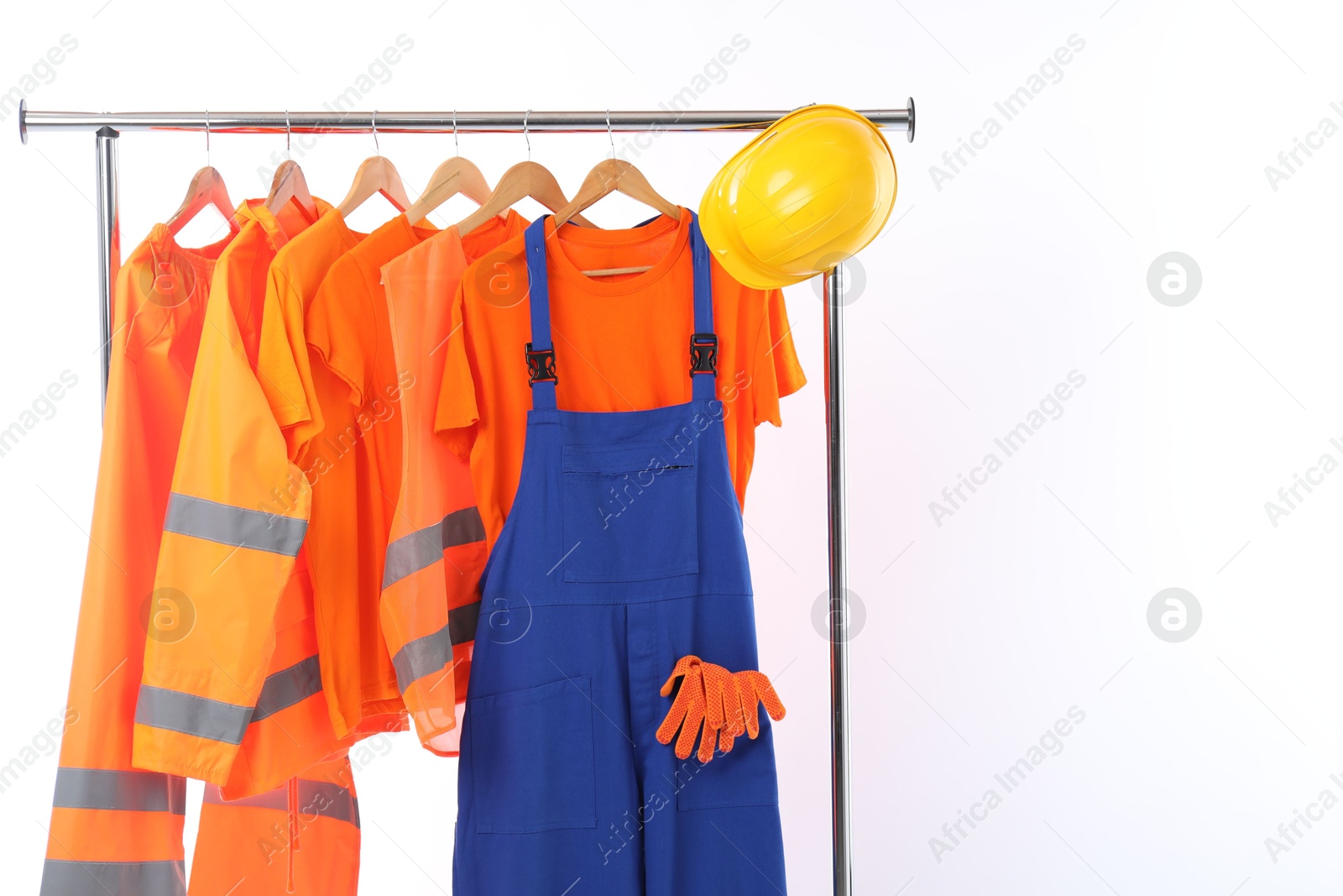 Photo of Workers' uniforms on clothing rack on white background. Space for text