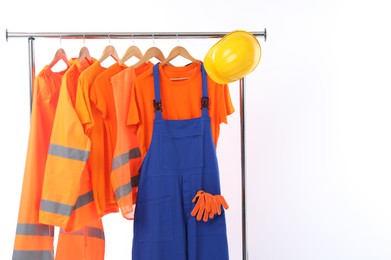 Workers' uniforms on clothing rack on white background. Space for text