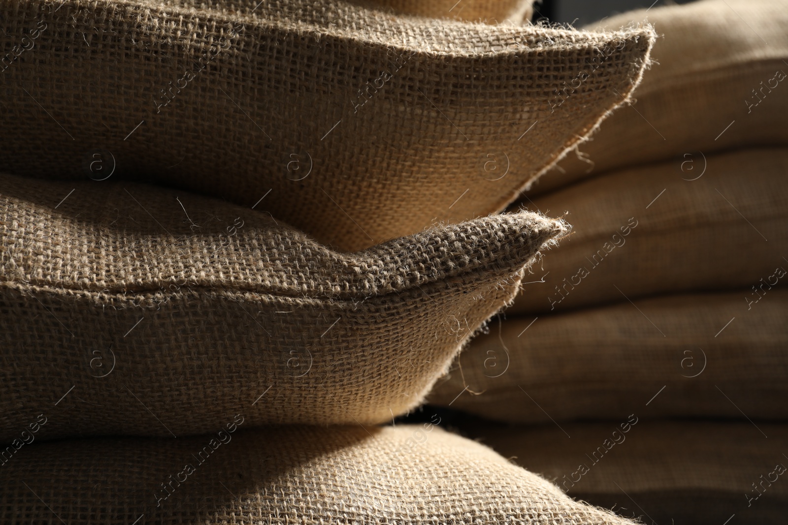 Photo of Closeup view of many natural burlap sacks