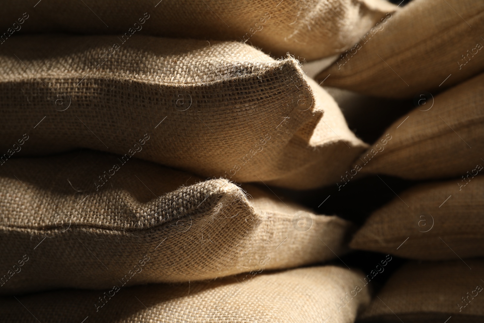 Photo of Closeup view of many natural burlap sacks