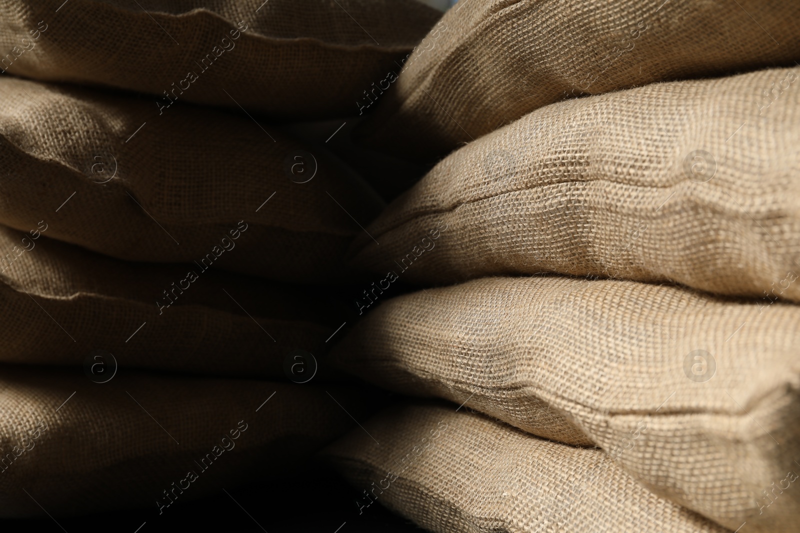 Photo of Closeup view of many natural burlap sacks