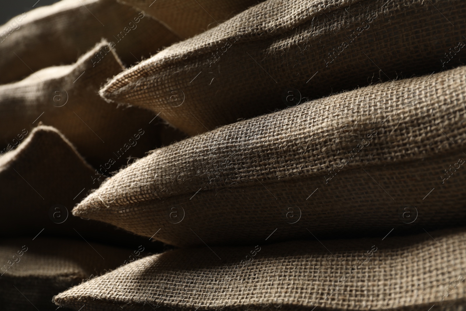 Photo of Closeup view of many natural burlap sacks