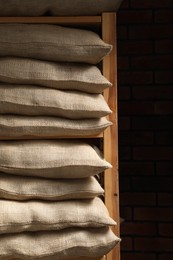 Group of burlap sacks on shelving unit near brick wall