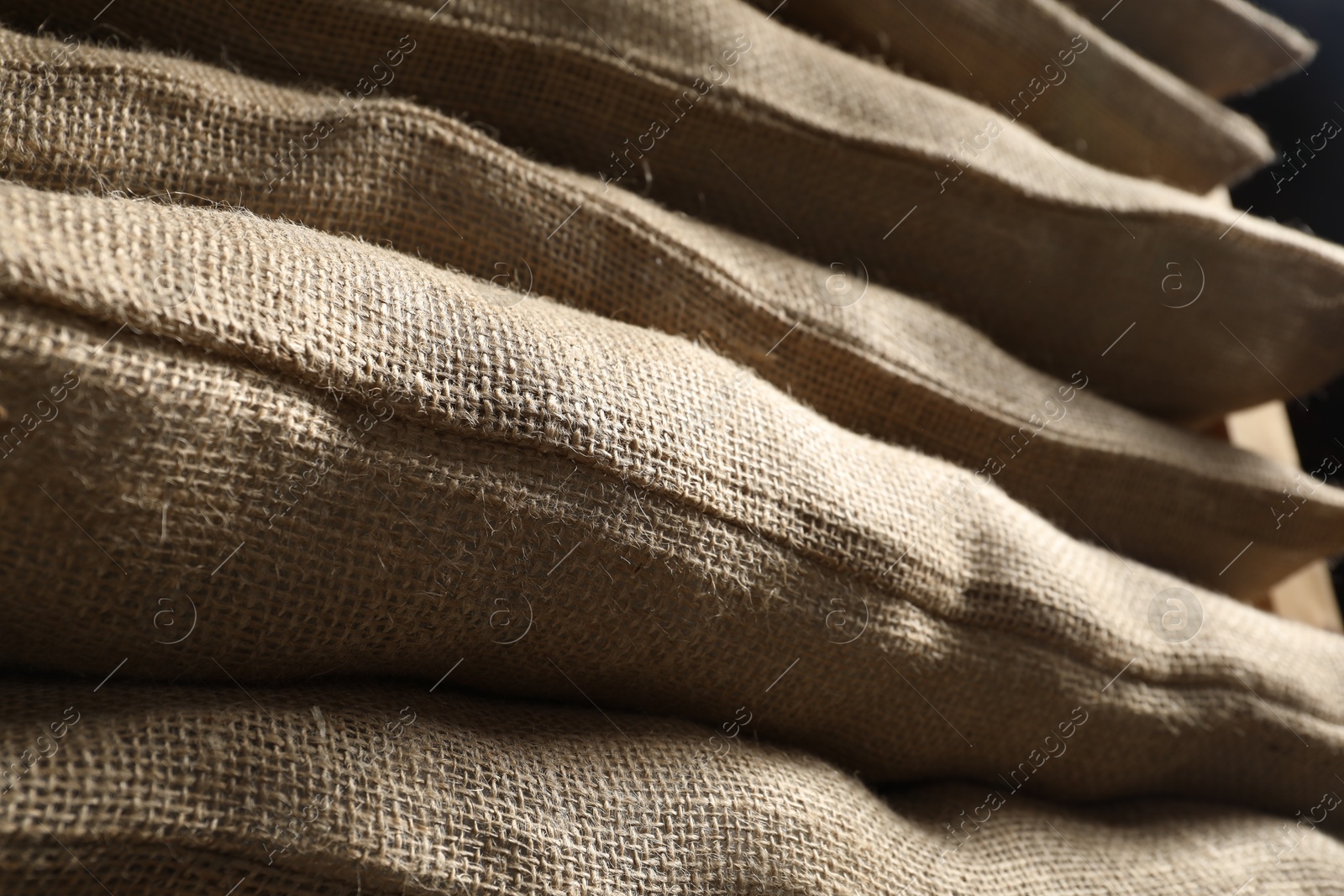 Photo of Closeup view of many natural burlap sacks