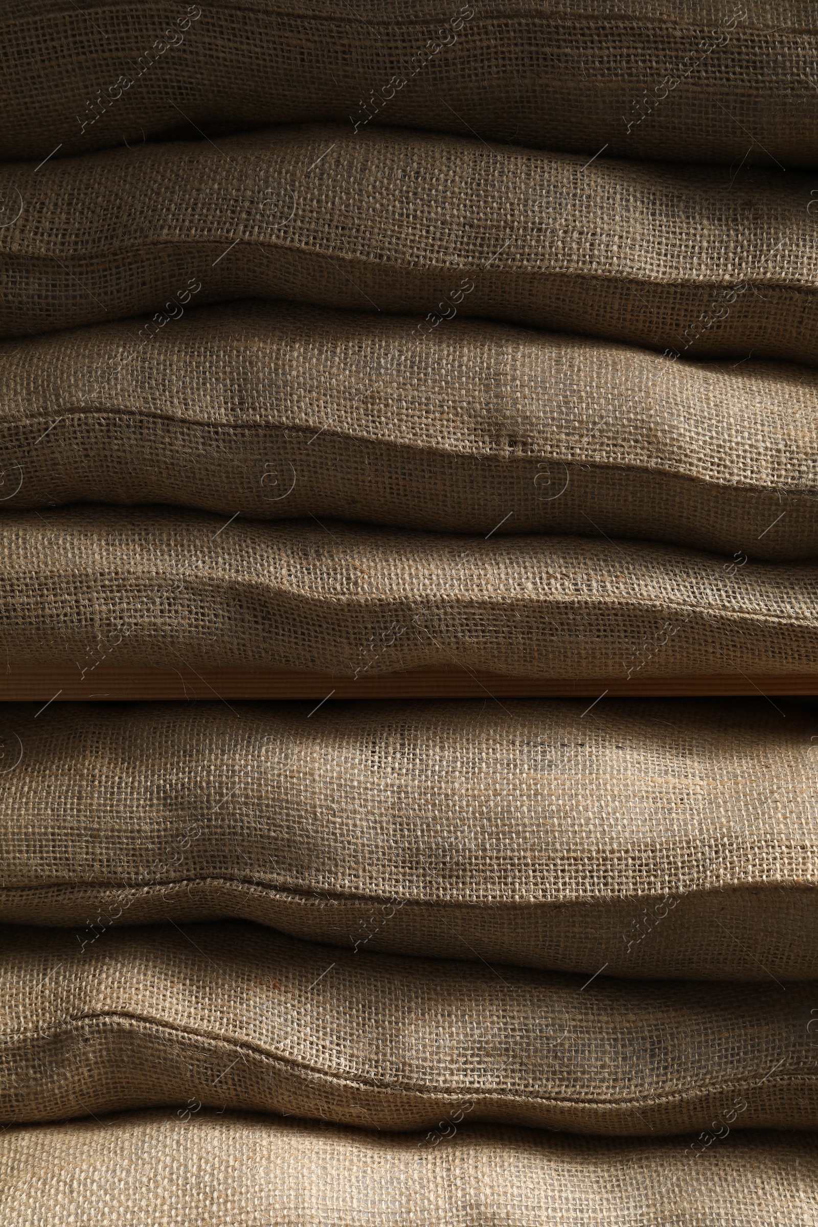 Photo of Closeup view of many natural burlap sacks