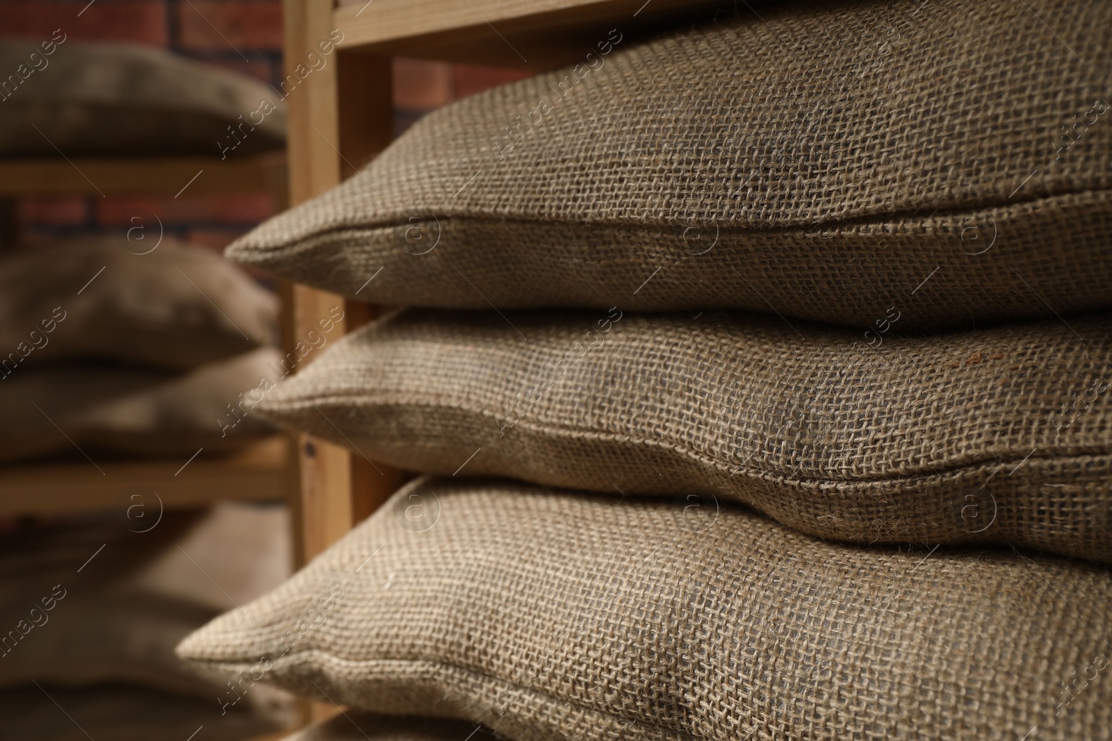 Photo of Group of burlap sacks on shelving unit indoors, closeup