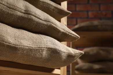 Group of burlap sacks on shelving unit indoors, closeup