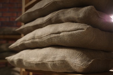 Photo of Group of burlap sacks on shelving unit indoors, closeup