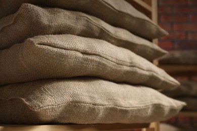 Photo of Group of burlap sacks on shelving unit indoors, closeup