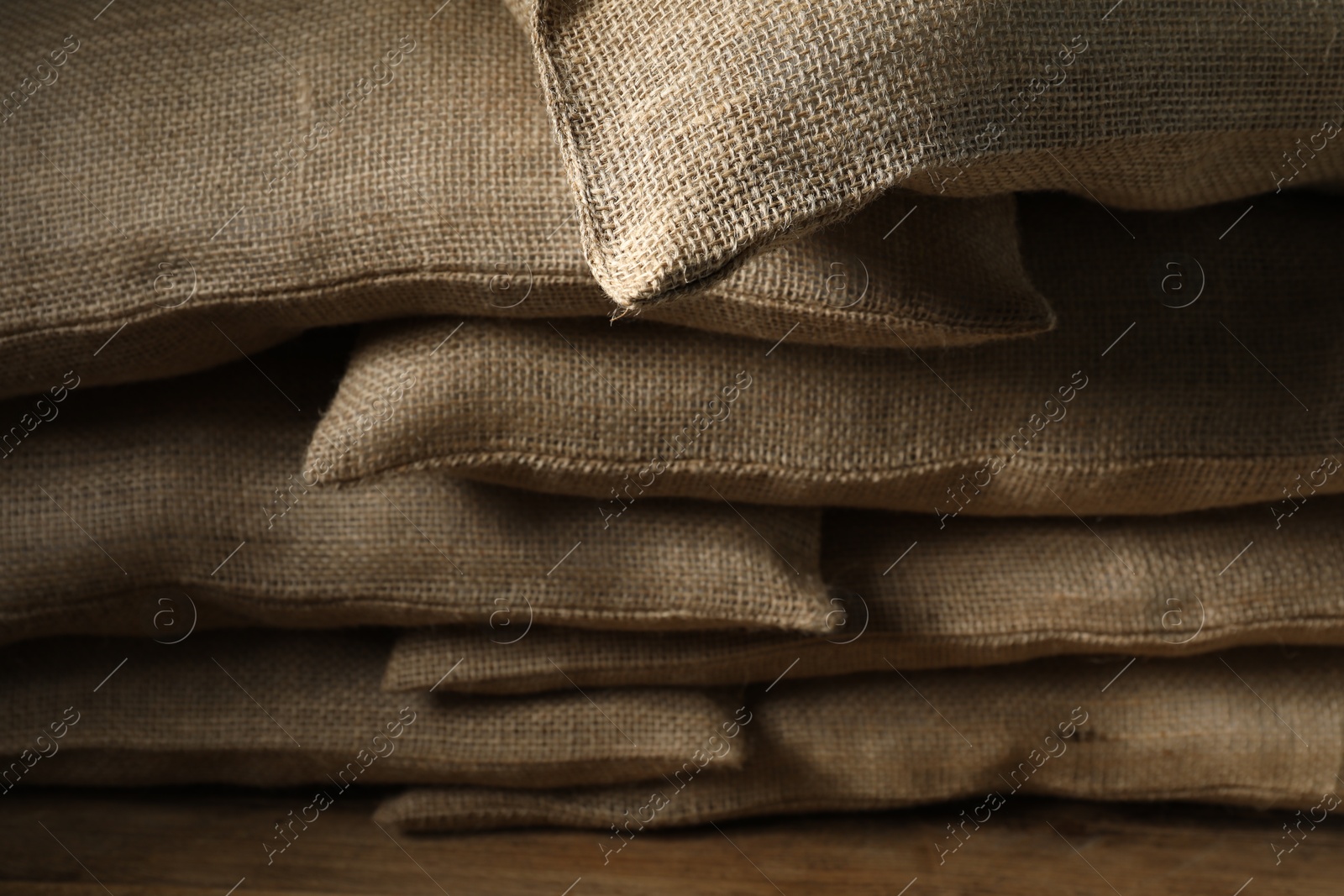 Photo of Group of burlap sacks on wooden table, closeup