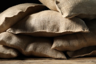 Photo of Group of burlap sacks on wooden table, closeup