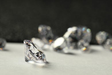 Photo of Beautiful dazzling diamonds on light grey table, closeup