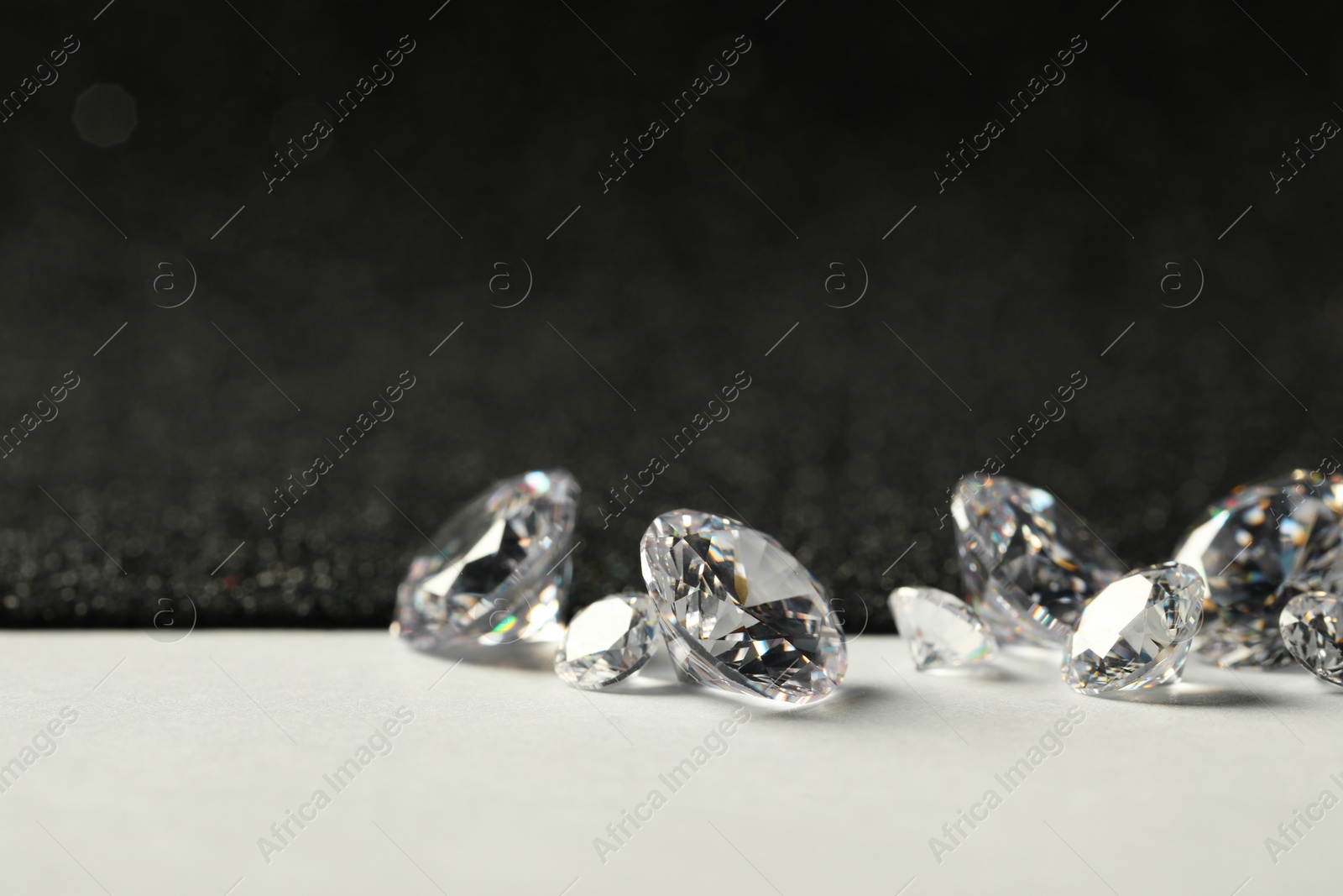 Photo of Beautiful dazzling diamonds on light grey table, closeup