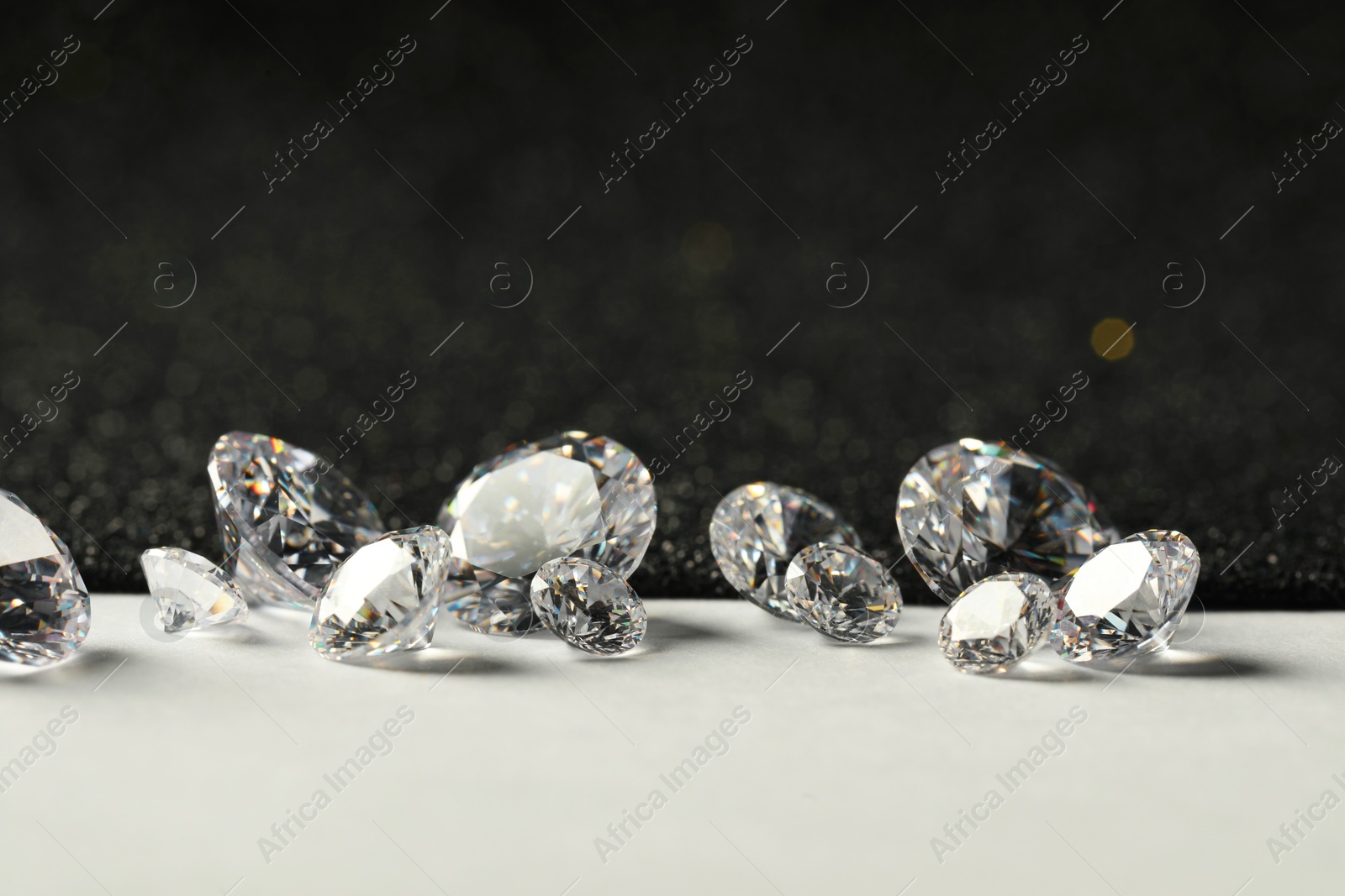 Photo of Beautiful dazzling diamonds on light grey table, closeup