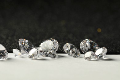 Beautiful dazzling diamonds on light grey table, closeup