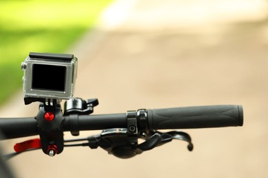 Modern action camera with mount on bicycle outdoors, closeup