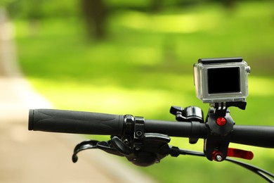 Modern action camera with mount on bicycle outdoors, closeup