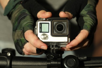 Photo of Man with modern action camera on bicycle outdoors, closeup