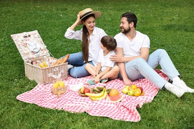 Family picnic. Happy parents and their son spending time together in park