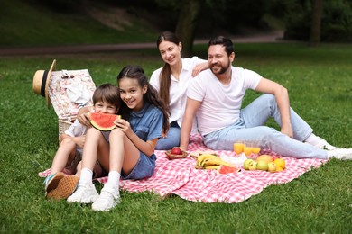 Happy family having picnic together in park