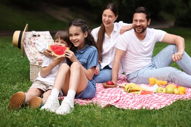 Happy family having picnic together in park