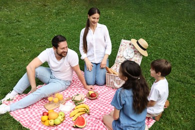 Photo of Happy family having picnic together in park