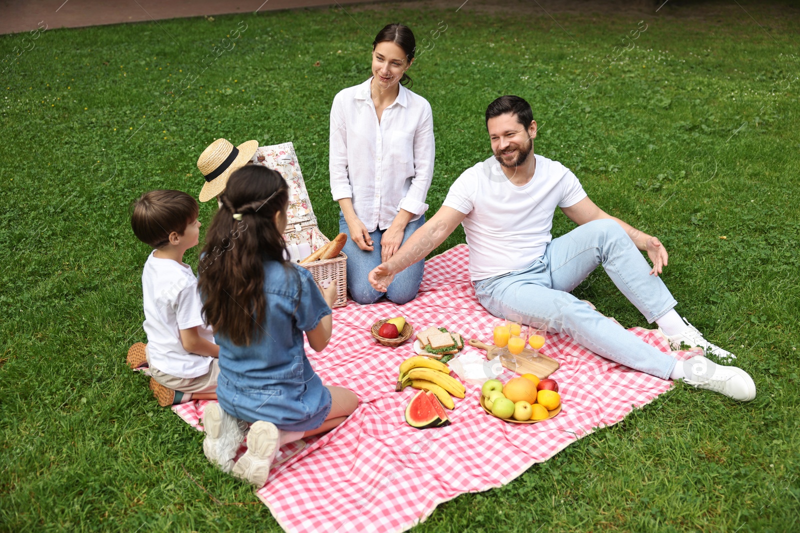 Photo of Happy family having picnic together in park