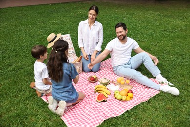 Photo of Happy family having picnic together in park