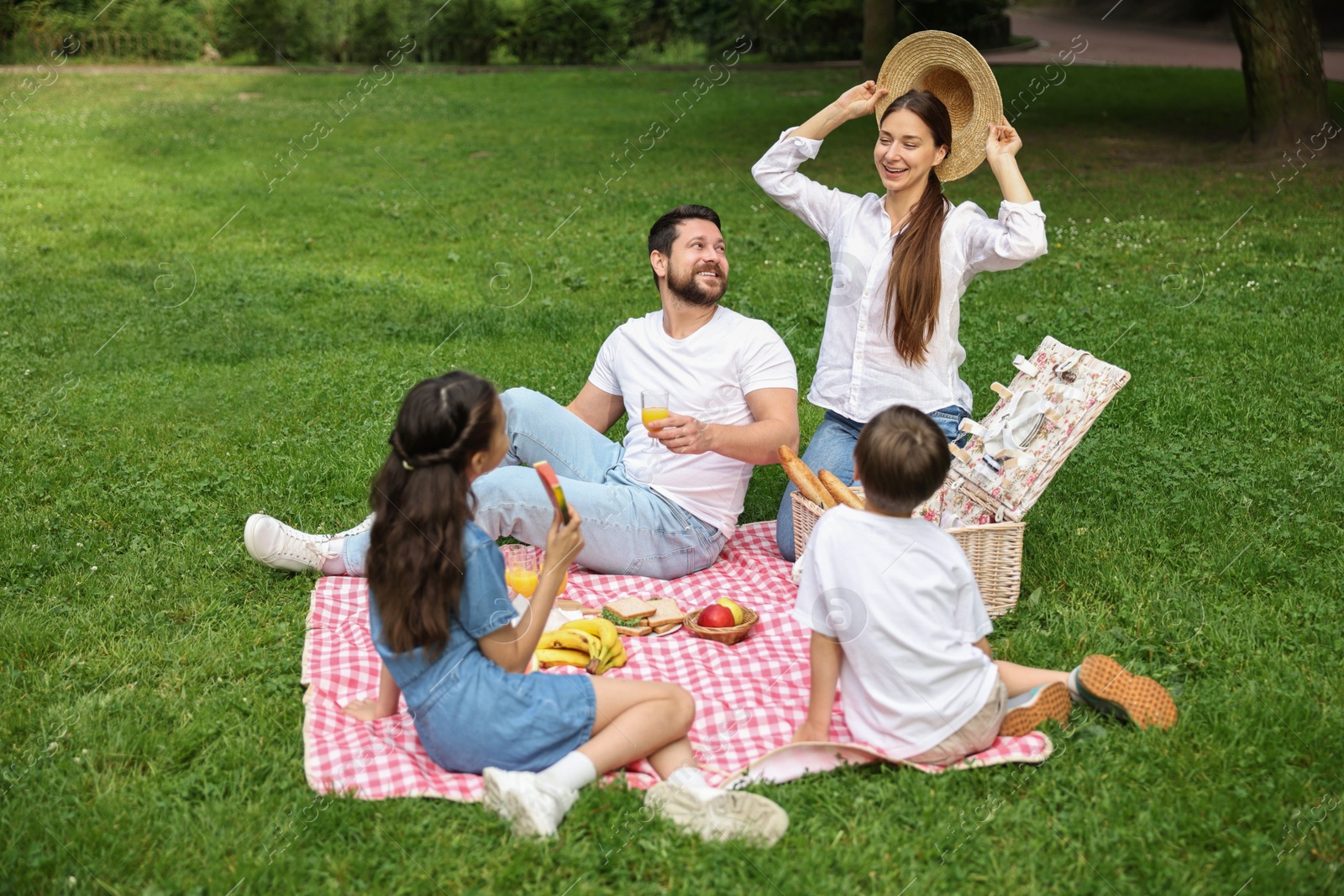 Photo of Happy family having picnic together in park