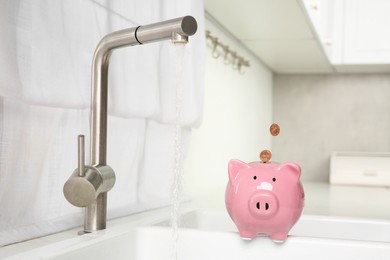 Photo of Water saving concept. Coins falling into piggy bank and stream of water flowing from tap in kitchen