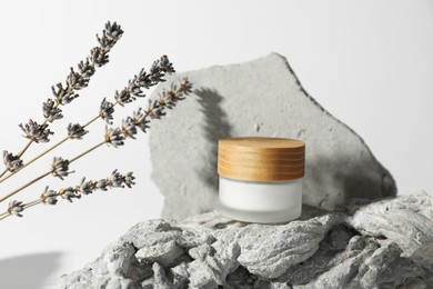 Photo of Facial cream in jar and lavender on white background