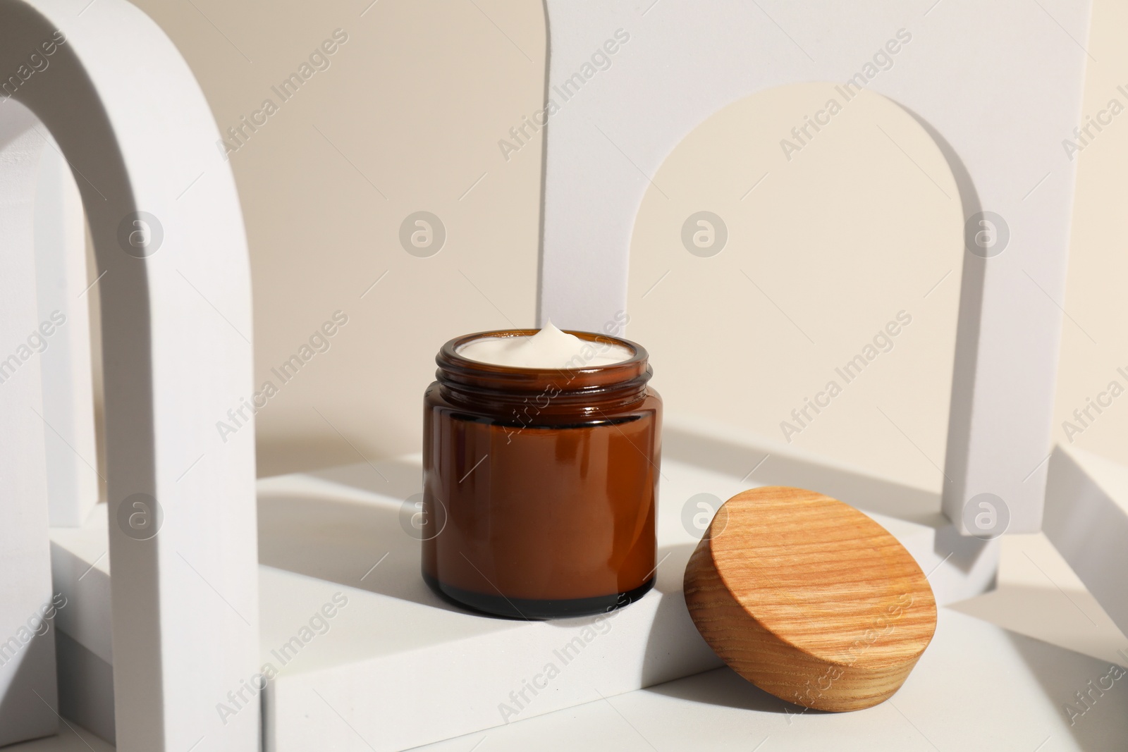 Photo of Stylish presentation of facial cream on beige background