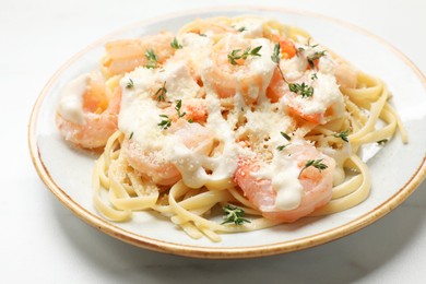 Photo of Tasty pasta with shrimps, creamy sauce and cheese on white table, closeup