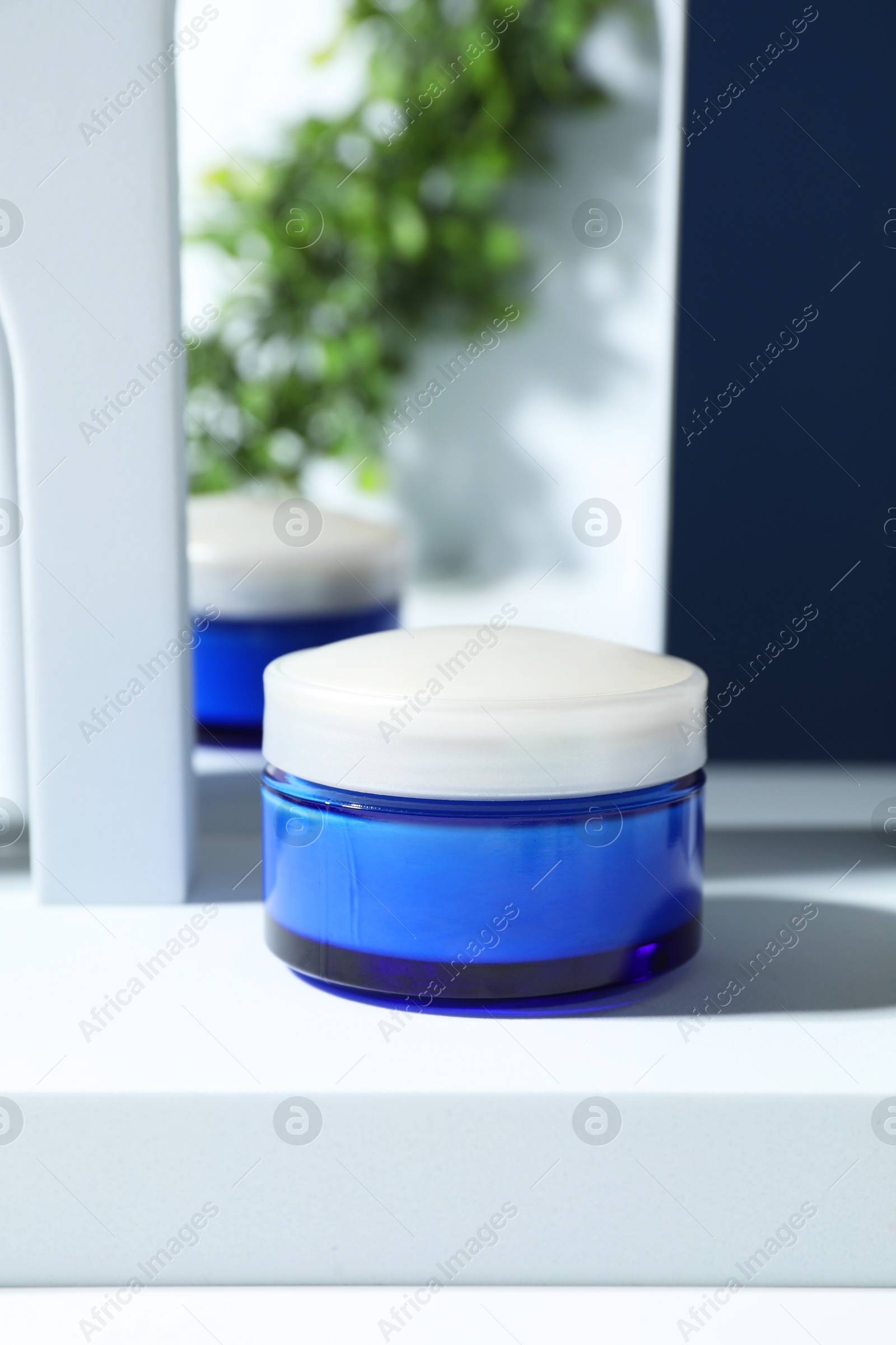 Photo of Stylish presentation of face cream against blue background