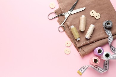 Photo of Flat lay composition with different sewing supplies on pink background. Space for text