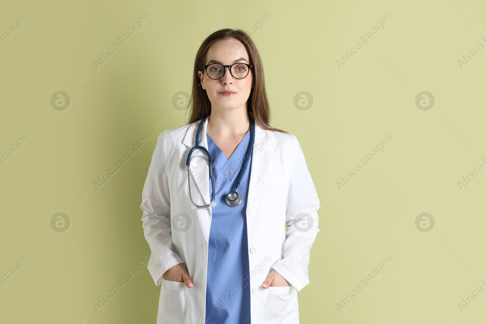 Photo of Portrait of professional nurse with stethoscope on pale green background