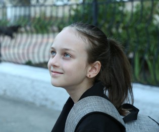 Photo of Portrait of girl with backpack on city street