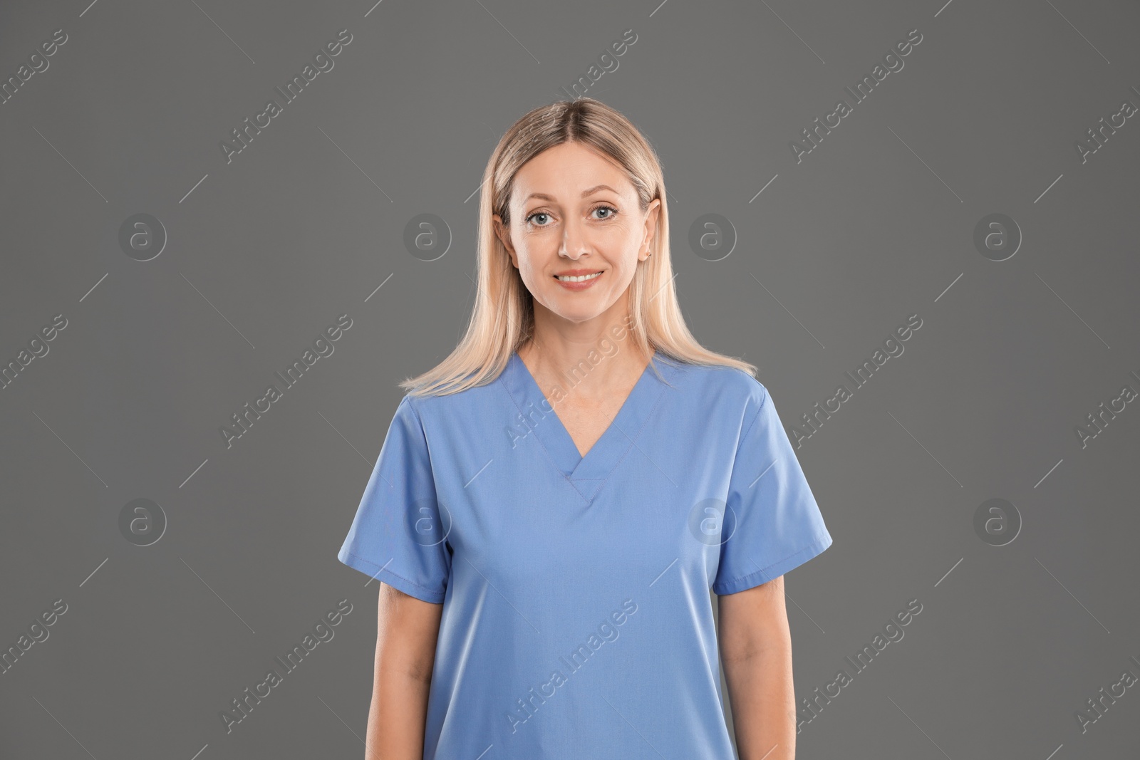 Photo of Portrait of nurse in medical uniform on grey background