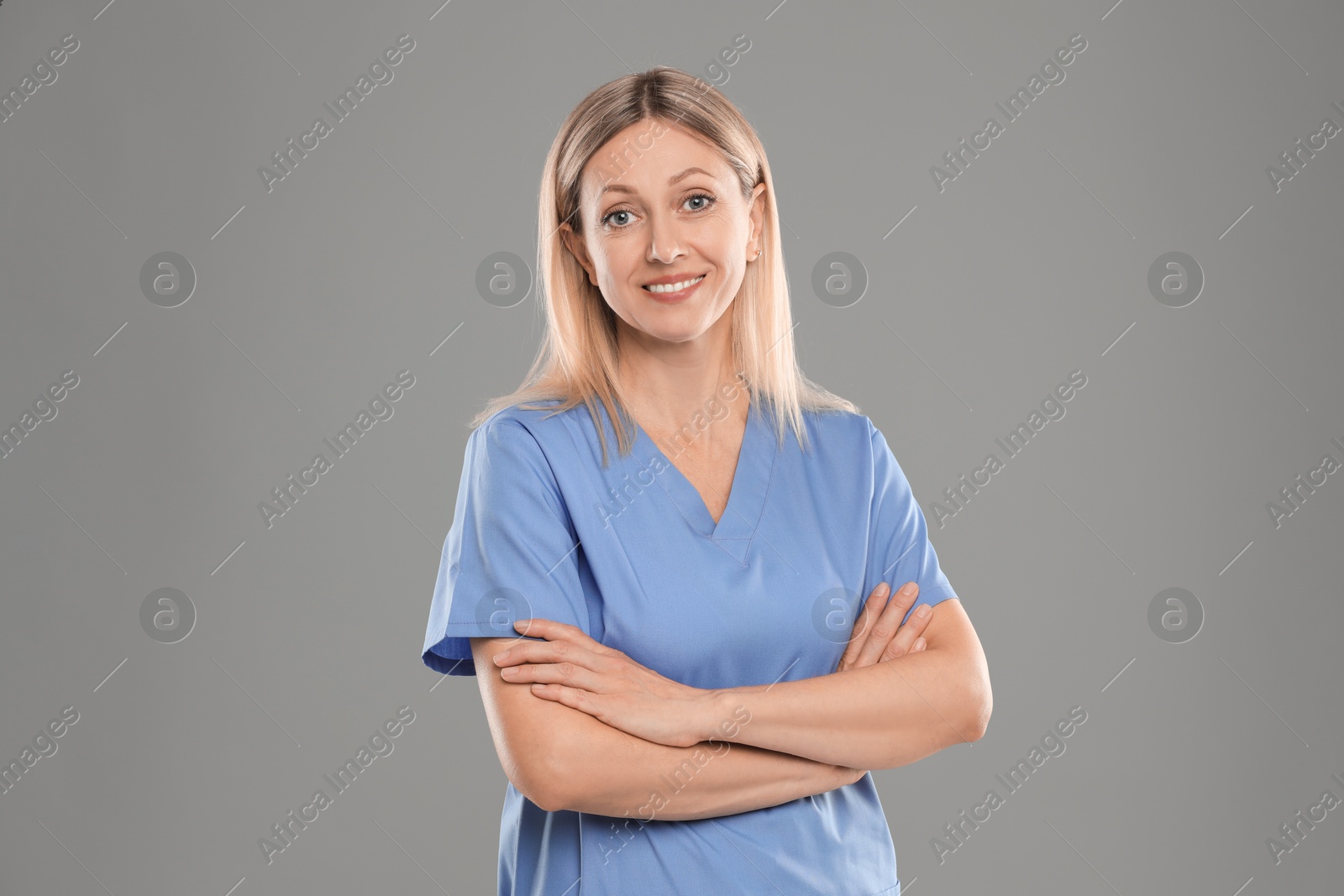 Photo of Portrait of nurse in medical uniform on grey background