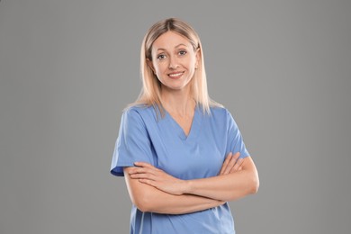 Portrait of nurse in medical uniform on grey background