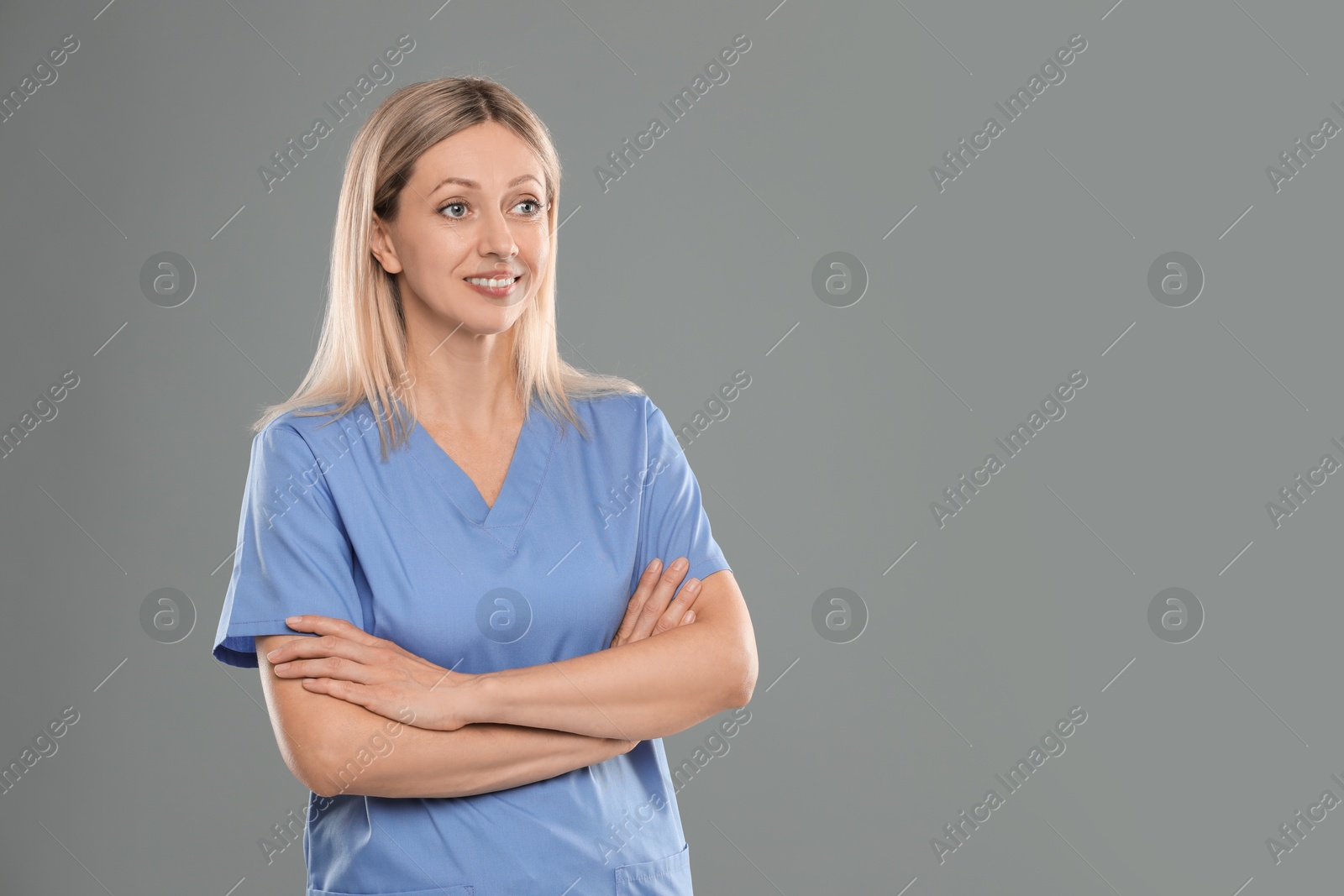 Photo of Portrait of nurse in medical uniform on grey background, space for text