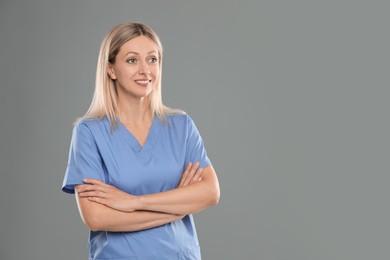 Photo of Portrait of nurse in medical uniform on grey background, space for text