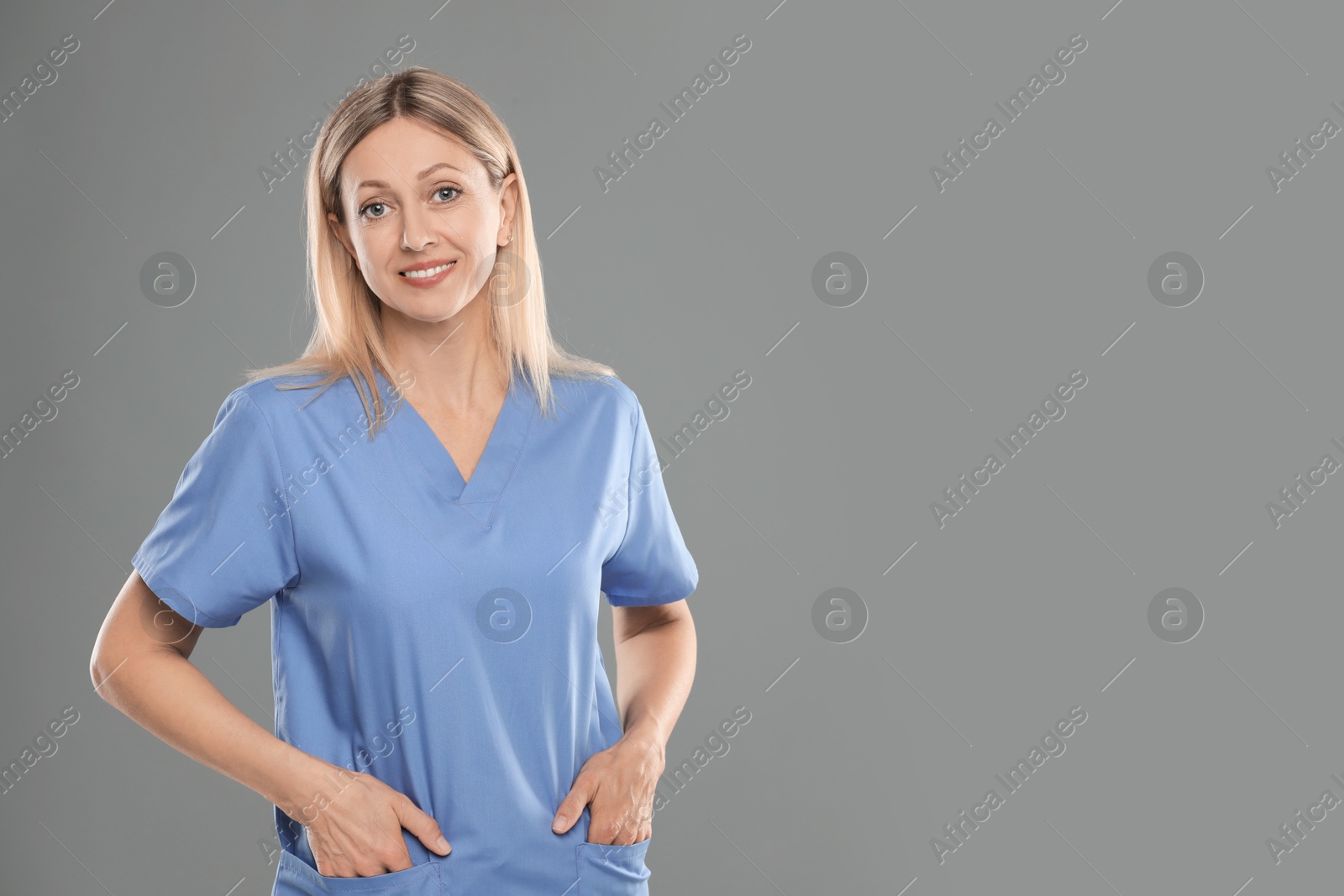 Photo of Portrait of nurse in medical uniform on grey background, space for text