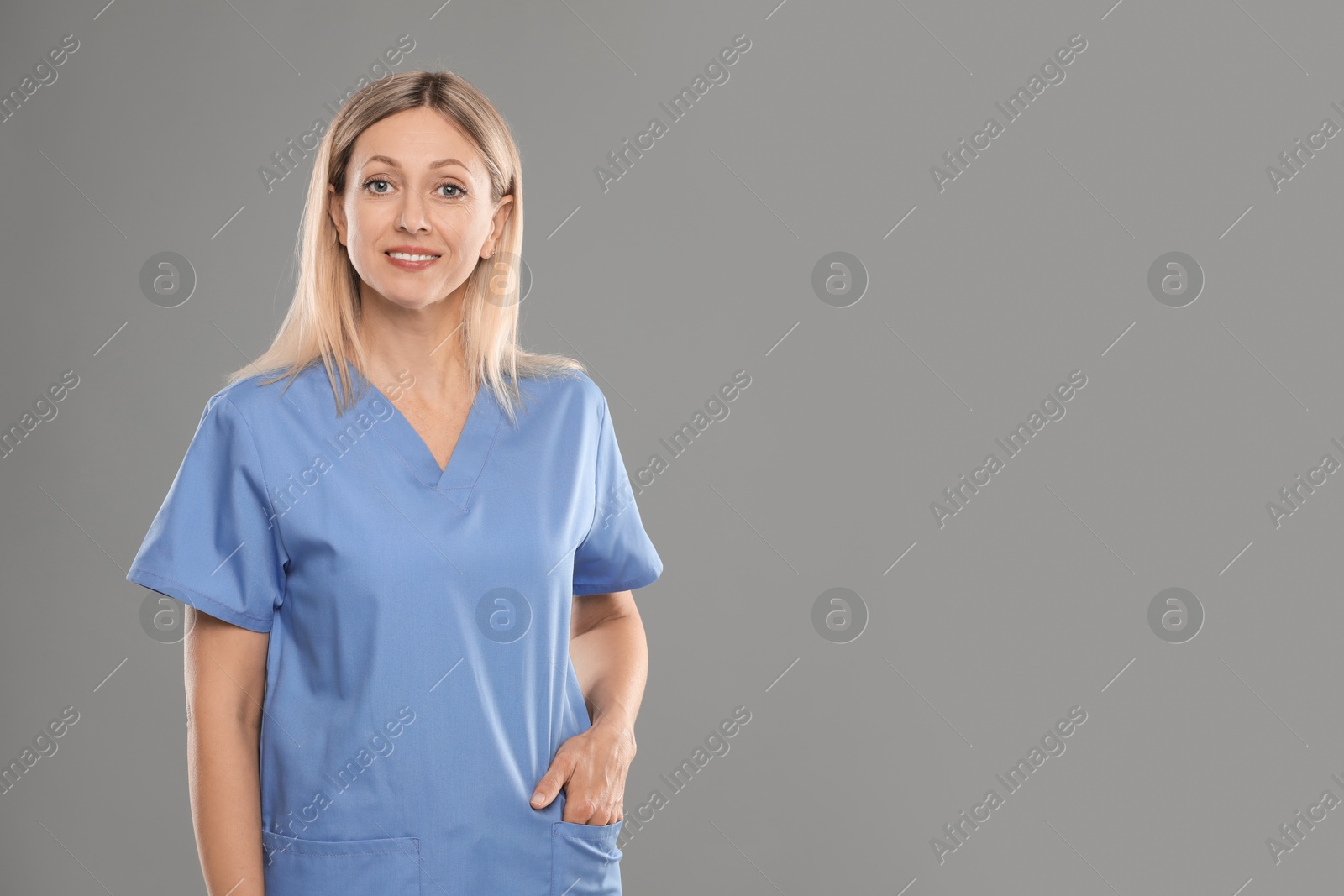 Photo of Portrait of nurse in medical uniform on grey background, space for text