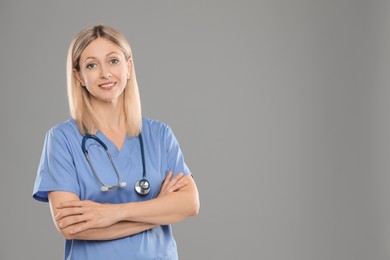 Photo of Portrait of doctor in medical uniform with stethoscope on grey background, space for text