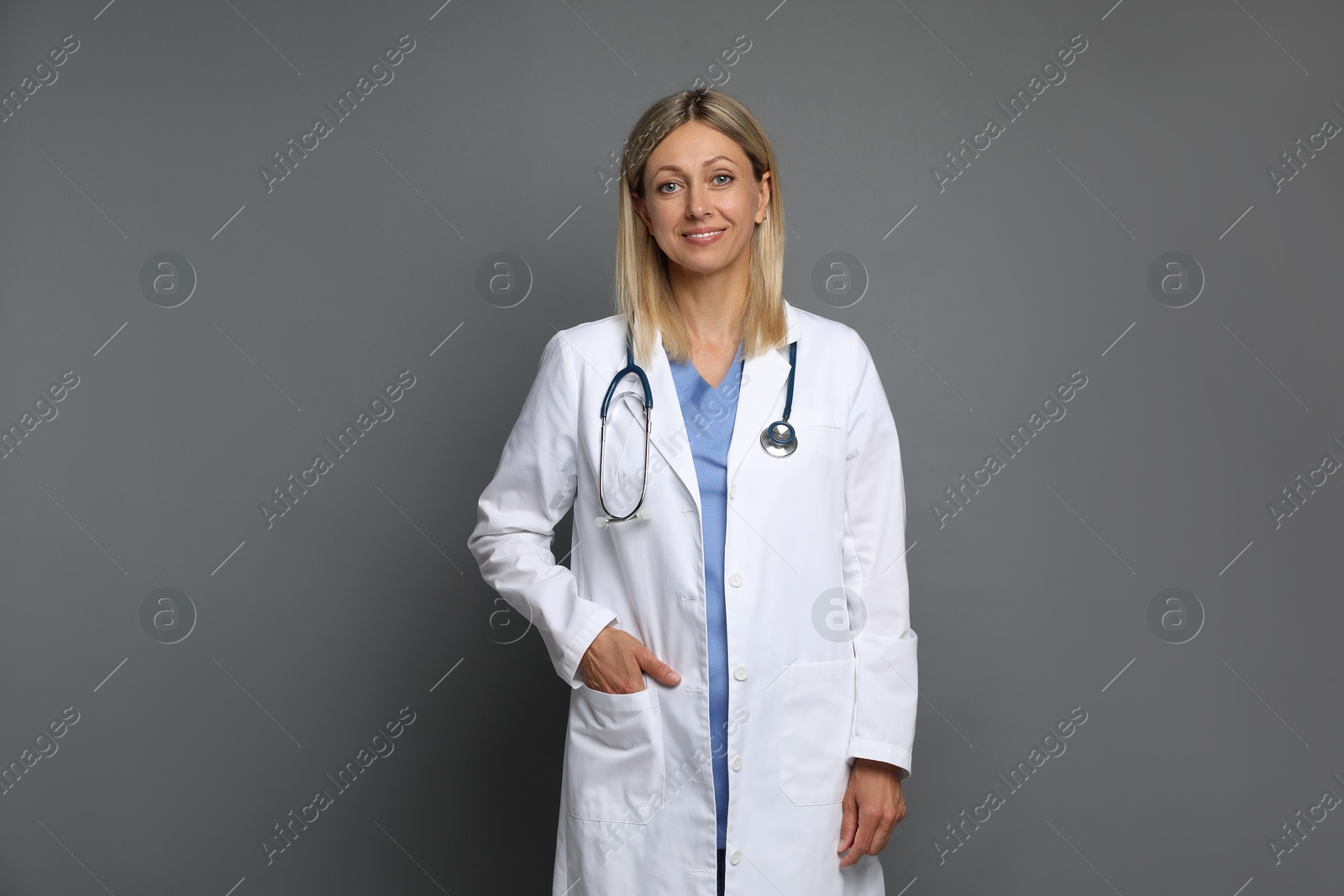 Photo of Portrait of doctor in medical uniform with stethoscope on grey background