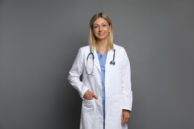 Portrait of doctor in medical uniform with stethoscope on grey background