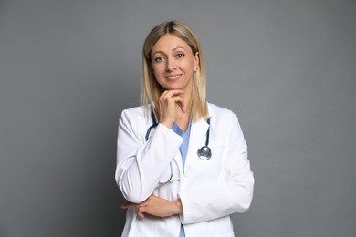 Portrait of doctor in medical uniform with stethoscope on grey background